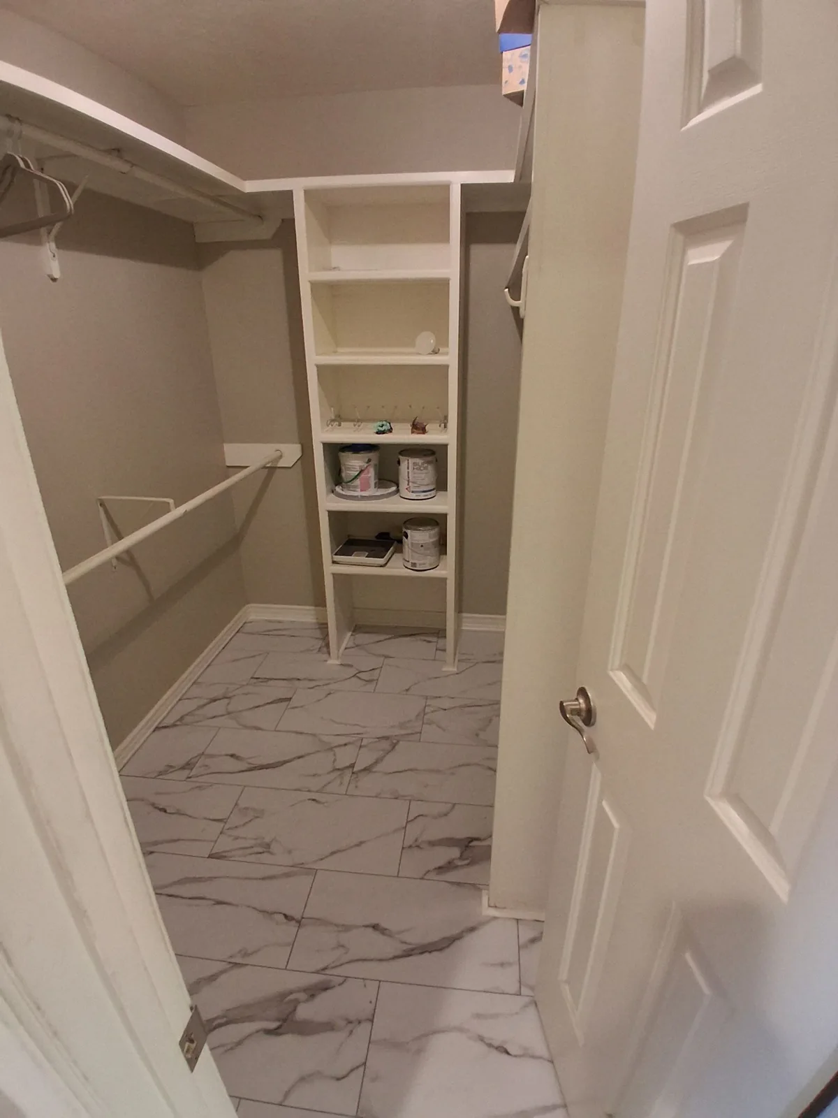 Open closet with built-in white shelves and hanging rails